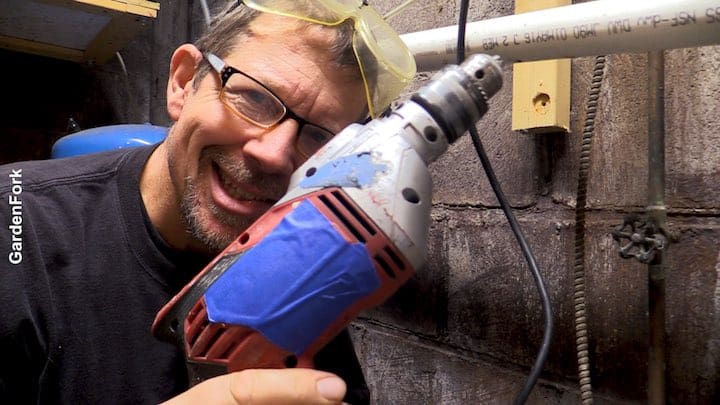 A man wearing safety glasses holding a drill